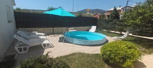 une terrasse avec une piscine, des chaises et un parasol dans l'établissement Family friendly apartments with a swimming pool Kastel Stafilic, Kastela - 18062, à Kaštela