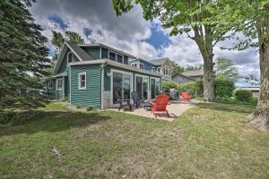 a green house with a patio in the yard at Lakeside Retreat with Office and Stunning Views! in Portage