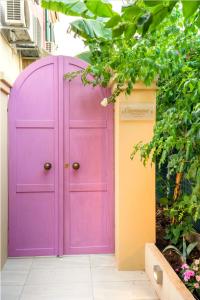 a purple door in the side of a building at Carmena Residence in Skala Kefalonias