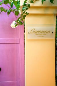 a door with a sign on it next to a pink door at Carmena Residence in Skala Kefalonias