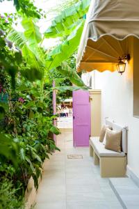 a patio with a purple door and green plants at Carmena Residence in Skala Kefalonias