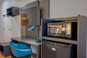 a kitchen with a microwave and a blue chair at Motel 6-Denison, TX in Denison
