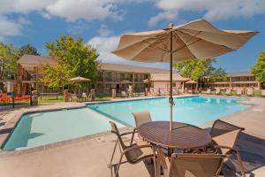 uma mesa com um guarda-sol ao lado de uma piscina em Best Western Plus Burley Inn & Convention Center em Burley