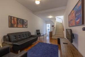 a living room with a leather couch and a blue rug at Casa no Tatuapé com 3 Dormitórios e Garagem in Sao Paulo