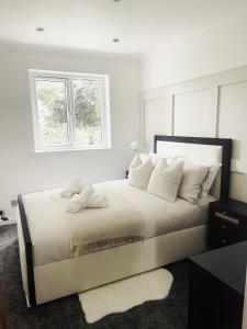 a white bedroom with a large bed with white pillows at D abode Devon in Torquay