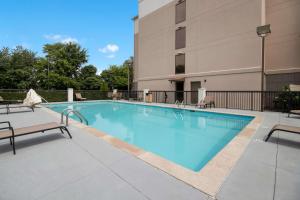 a swimming pool with chairs and a building at Best Western Suites near Opryland in Nashville