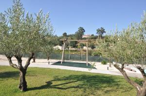 a park with trees in front of a swing at Olival da Seara in Marco de Canavezes