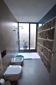 baño con 2 aseos, lavamanos y ventana en Olival da Seara en Marco de Canavezes