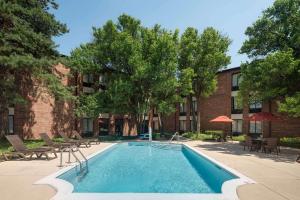 a swimming pool with chairs and a building at Best Western Chicago - Downers Grove in Downers Grove