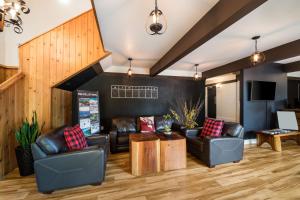 sala de estar con sofás de cuero y mesa en Stoke Hotel SureStay Collection by Best Western, en Revelstoke