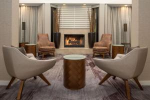 a waiting room with chairs and a fireplace at Sonesta Select Seattle Bellevue Redmond in Bellevue