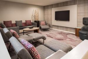 a living room with couches and a flat screen tv at Sonesta Select Seattle Bellevue Redmond in Bellevue