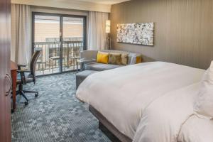 a hotel room with a bed and a chair and a desk at Sonesta Select Seattle Bellevue Redmond in Bellevue