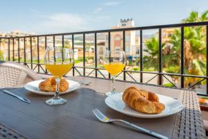 una mesa con dos copas de vino y cruasanes en Apartamento Coral, en Torrox Costa