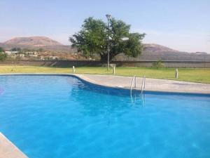 a large blue swimming pool next to a park at Casa del Caucaso in Xochitepec