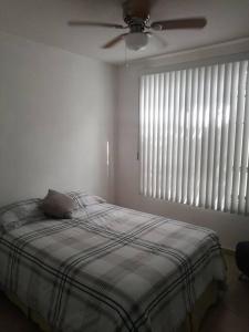 a bedroom with a bed with a ceiling fan and a window at Casa del Caucaso in Xochitepec +18 photos