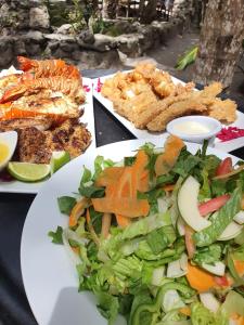 a table topped with plates of vegetables and other foods at Bella Vista Resort Belize in San Pedro