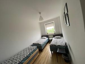 une chambre avec deux lits et une fenêtre dans l'établissement Pokoje Polinezyjska, à Varsovie