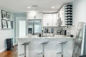 a kitchen with white cabinets and a counter with stools at Grand Oaks Terminal in the Heights in Tampa