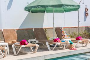three children laying on chairs next to a pool at Villa La marina in Nerja