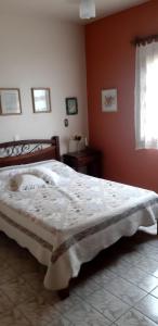 um quarto com uma cama numa parede vermelha em Chácara Tâmonamió - Casa de campo completa para sua família - WIFI fibra em Limeira