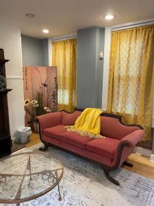 a living room with a red couch with a yellow blanket on it at Northern Liberties Retreat in Philadelphia