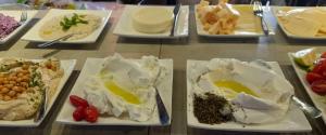 a table with several plates of food on it at Diaghilev LOFT live art hotel in Tel Aviv