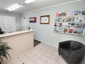 uma sala de espera com uma cadeira preta no balcão em Avon Motel em Hawera