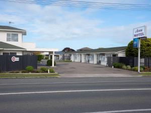 un panneau de rue devant une rangée de maisons dans l'établissement Avon Motel, à Hawera