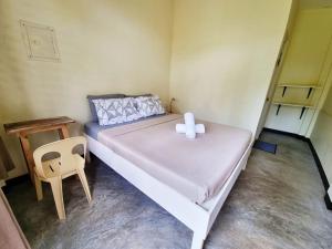 um pequeno quarto com uma cama e uma cadeira em Bahandi Beach Lodge em Mambajao