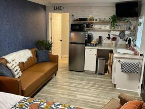 a living room with a couch and a kitchen at Cozy tiny home cabin in Eva, TN 