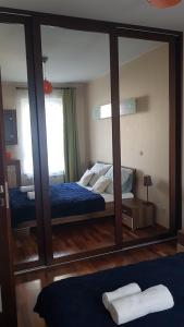 um espelho num quarto com uma cama e uma cama em Apartament z balkonem Przy parku em Varsóvia