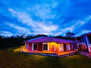 une petite maison avec un toit violet dans une cour dans l'établissement Hotel Kasama, à San Agustín