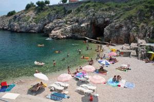 a group of people on a beach in the water at Double Room Vrbnik 5301b in Vrbnik