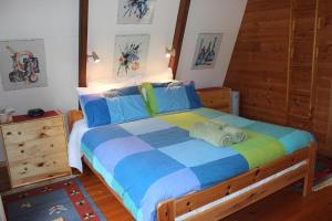 a bedroom with a large bed with blue and colorful sheets at Green Leaves Cabin in Denmark