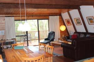 a living room with a table and a couch at Green Leaves Cabin in Denmark