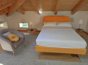 ein Schlafzimmer mit einem großen Bett und einem Stuhl in der Unterkunft Agriturismo CapoCasale in Santa Barbara