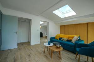ein Wohnzimmer mit einem blauen Sofa und einem Tisch in der Unterkunft La Tournette superb quiet apartment 300 meters from the lake in Sévrier