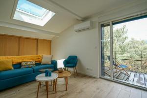 ein Wohnzimmer mit einem blauen Sofa und einem Fenster in der Unterkunft La Tournette superb quiet apartment 300 meters from the lake in Sévrier