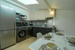 eine Küche mit einem Tisch und eine Küche mit einem Geschirrspüler in der Unterkunft La Tournette superb quiet apartment 300 meters from the lake in Sévrier