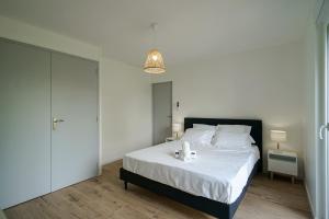 ein Schlafzimmer mit einem großen Bett mit weißen Laken und einer Lampe in der Unterkunft La Tournette superb quiet apartment 300 meters from the lake in Sévrier + 4 Fotos