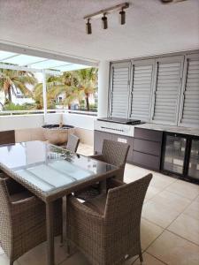 a dining room with a table and chairs and windows at Marriner Views in Gold Coast