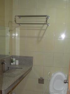 a bathroom with a toilet and a sink at Manora Apartment in Talisay