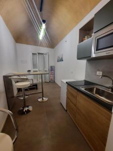 eine Küche mit einer Spüle, einem Tisch und einer Theke in der Unterkunft TURISMO EGADI - CHARME in Favignana