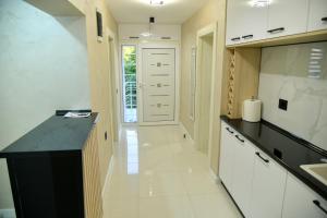 a kitchen with a black counter and white cabinets at Pansion Eden in Niš