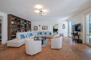 Una sala de estar con muebles blancos y un televisor. en Villa L'angelo Del Lario, en Carlazzo