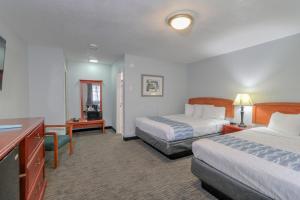 a hotel room with two beds and a desk at Belle Aire Motel - Downtown Convention Center - Gatlinburg in Gatlinburg
