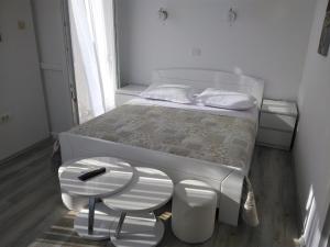 a white bedroom with a bed and a stool at Rooms with WiFi Vis - 8905 in Vis