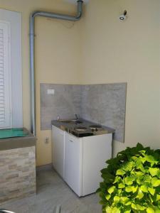 eine Küche mit einem Waschbecken in der Ecke eines Zimmers in der Unterkunft Rooms with WiFi Vis - 8905 in Vis