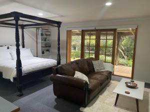 a living room with a couch and a bed at The Garden Suite in The Patch